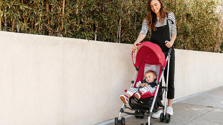 Mom Pushing Toddler in Red UPPAbaby G-Lite Stroller