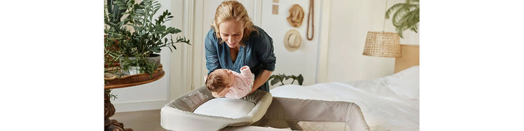 Mom Putting Baby on Changing Pad Attachment for Playard