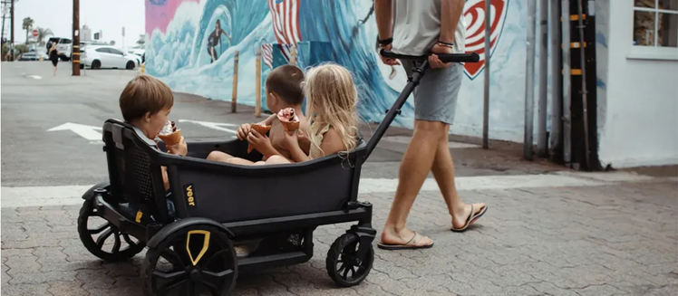Parent Pulling Children in Veer Wagon Stroller
