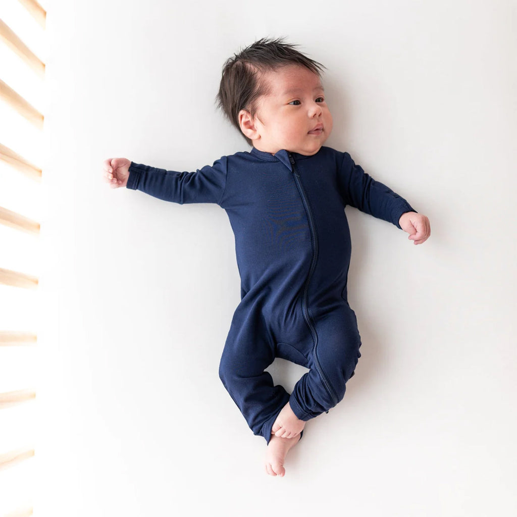 Cozy baby wearing the zipper romper in the color navy.