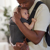 dad comforting infant in baby bjorn baby carrier mini charcoal grey