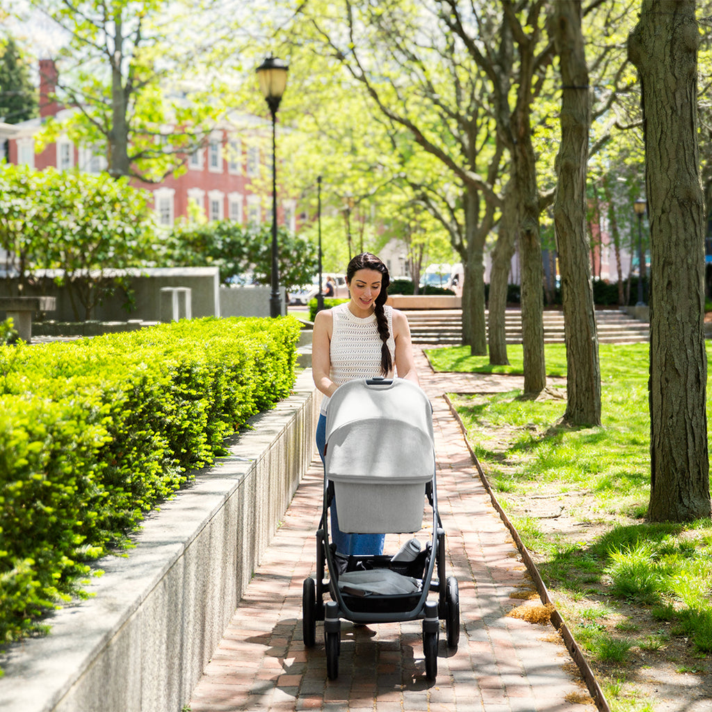 Mom Walking with Uppababy Cruz Stroller with Bassinet Accessory in Anthony