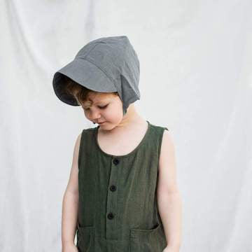 child wearingcharcoal Kyte Baby Linen Bonnet Hat Accessory