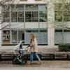 Woman Pushing Uppababy Cruz Stroller with Bassinet Accessory in Stella