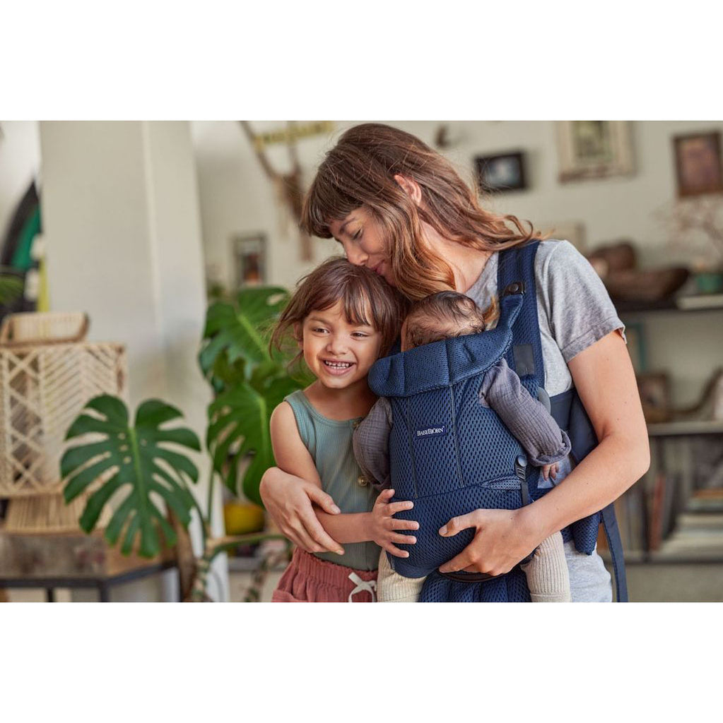 mom with two kids one in babybjorn carrier