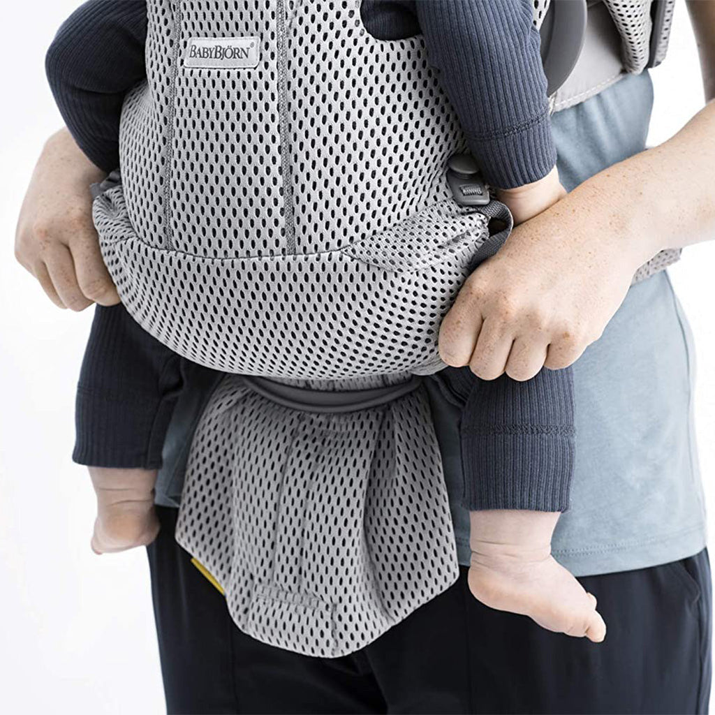 close up of baby supported in grey babybjorn free baby carrier