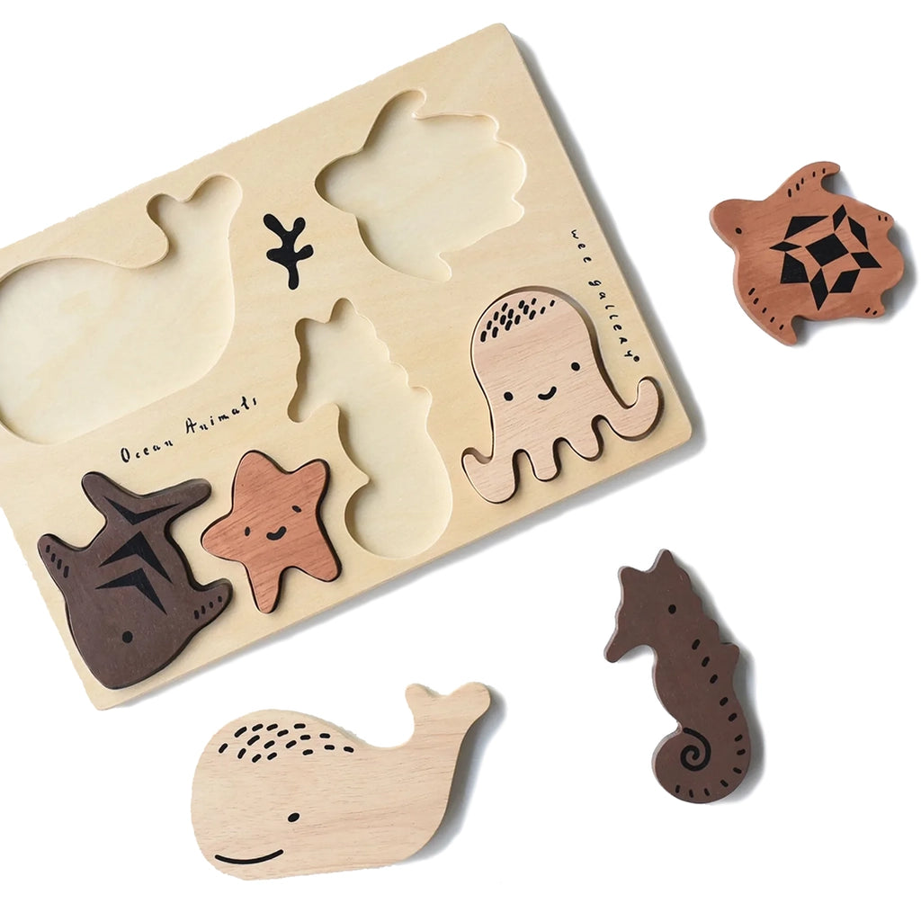 Wee Gallery Ocean Animals Wooden Tray Puzzle. Flatlay of three of the six pieces showing the tray with and without pieces.