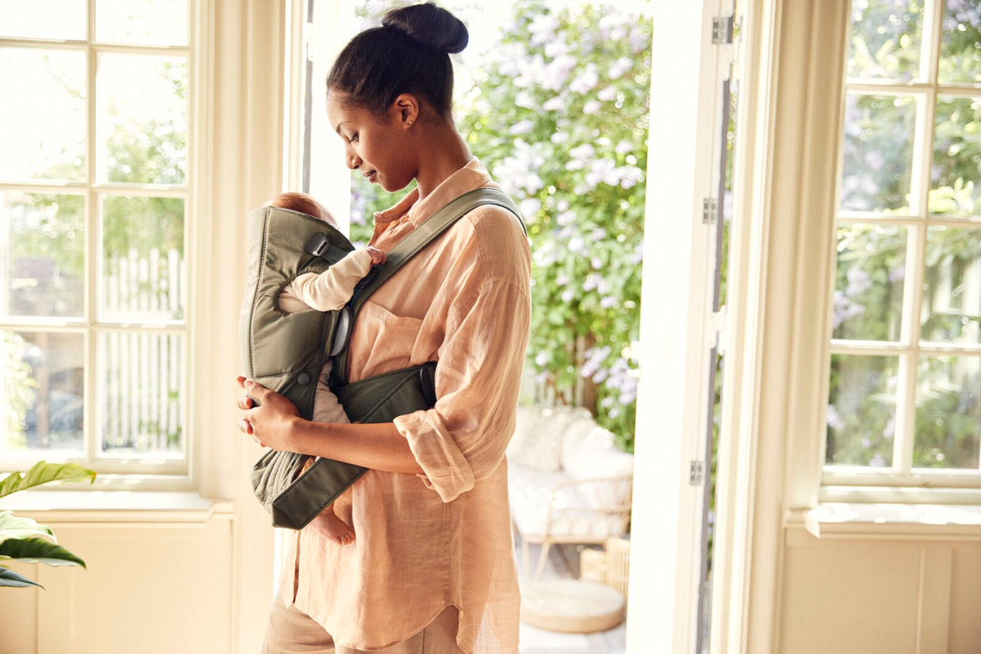 Mother babywearing infant with Babybjorn Baby Carrier Mini
