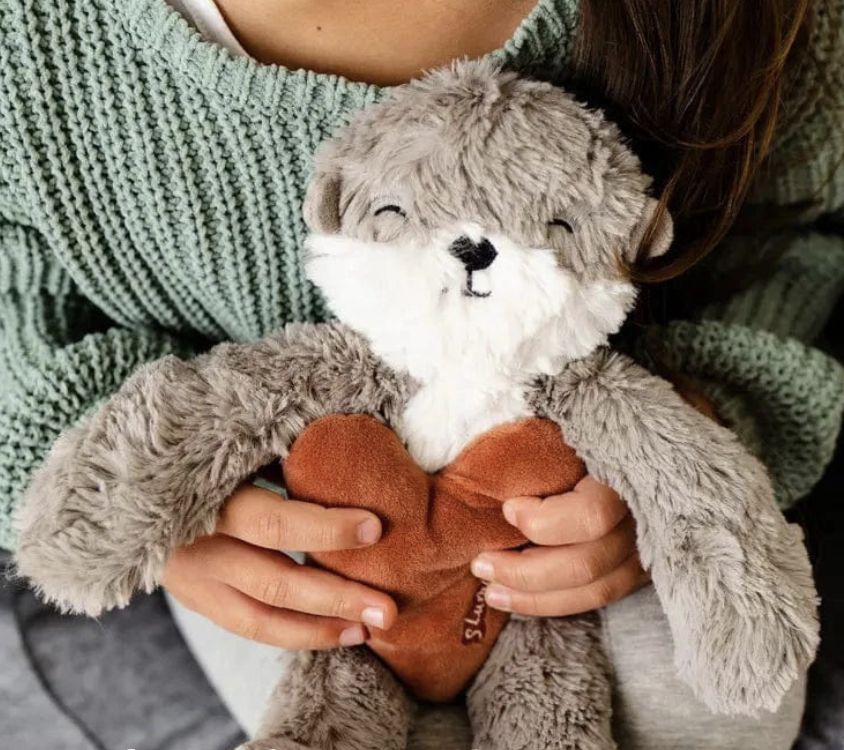 a child holding a teddy bear with a heart in her hands