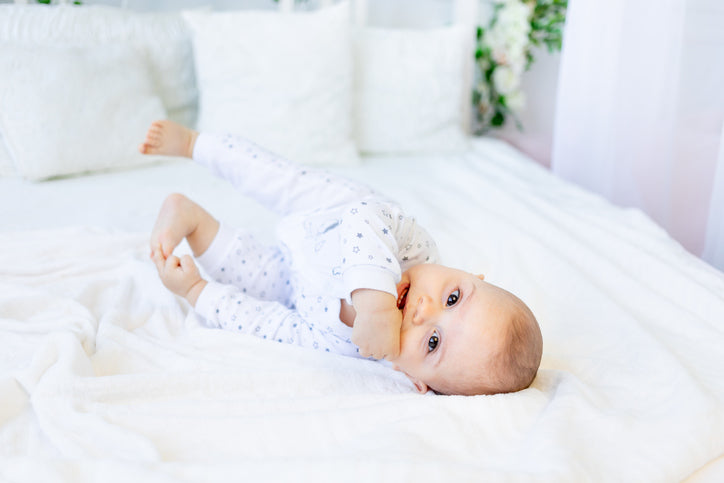 6 month old baby on bed