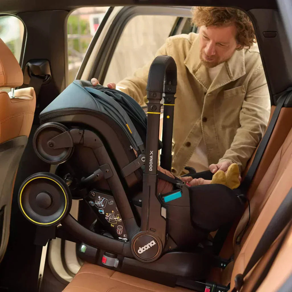 dad putting doona x infant car seat on LATCH car seat base