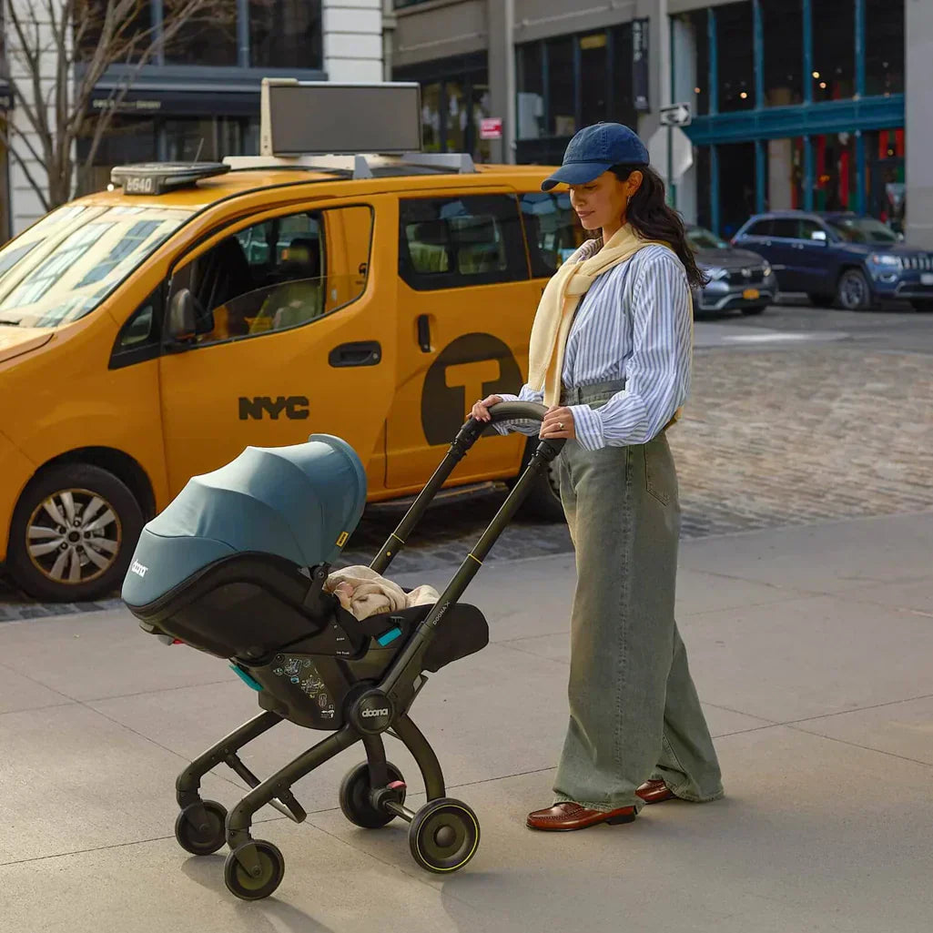 mother walking her infant in ocean blue doona x