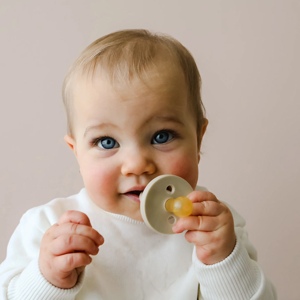 Cute Baby holding pacifier