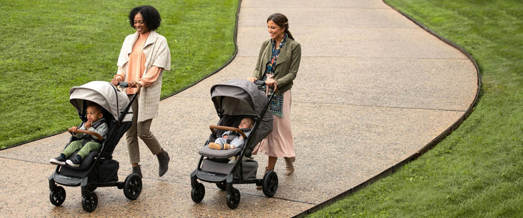 Two Moms Walk with Their Children in Strollers