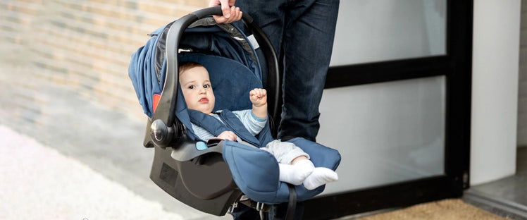 Parent Walking with Baby Sitting in Convertible Infant Car Seat