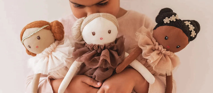 Little Girl Holding Three Cotton Dolls