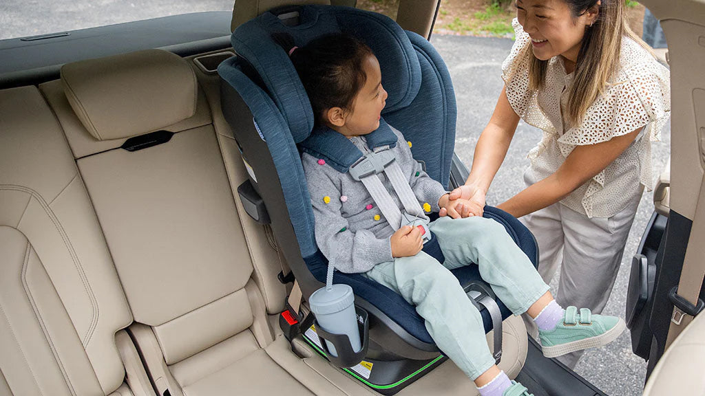 Woman Buckling Child into Blue UPPAbaby KNOX Convertible Car Seat