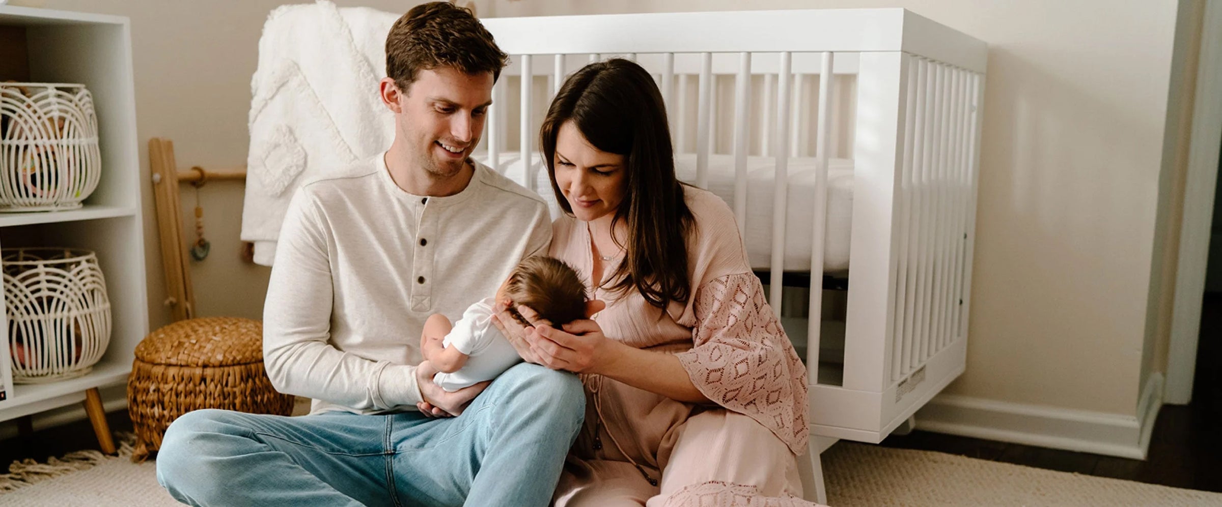 Parents Look at Newborn Baby in Nursery