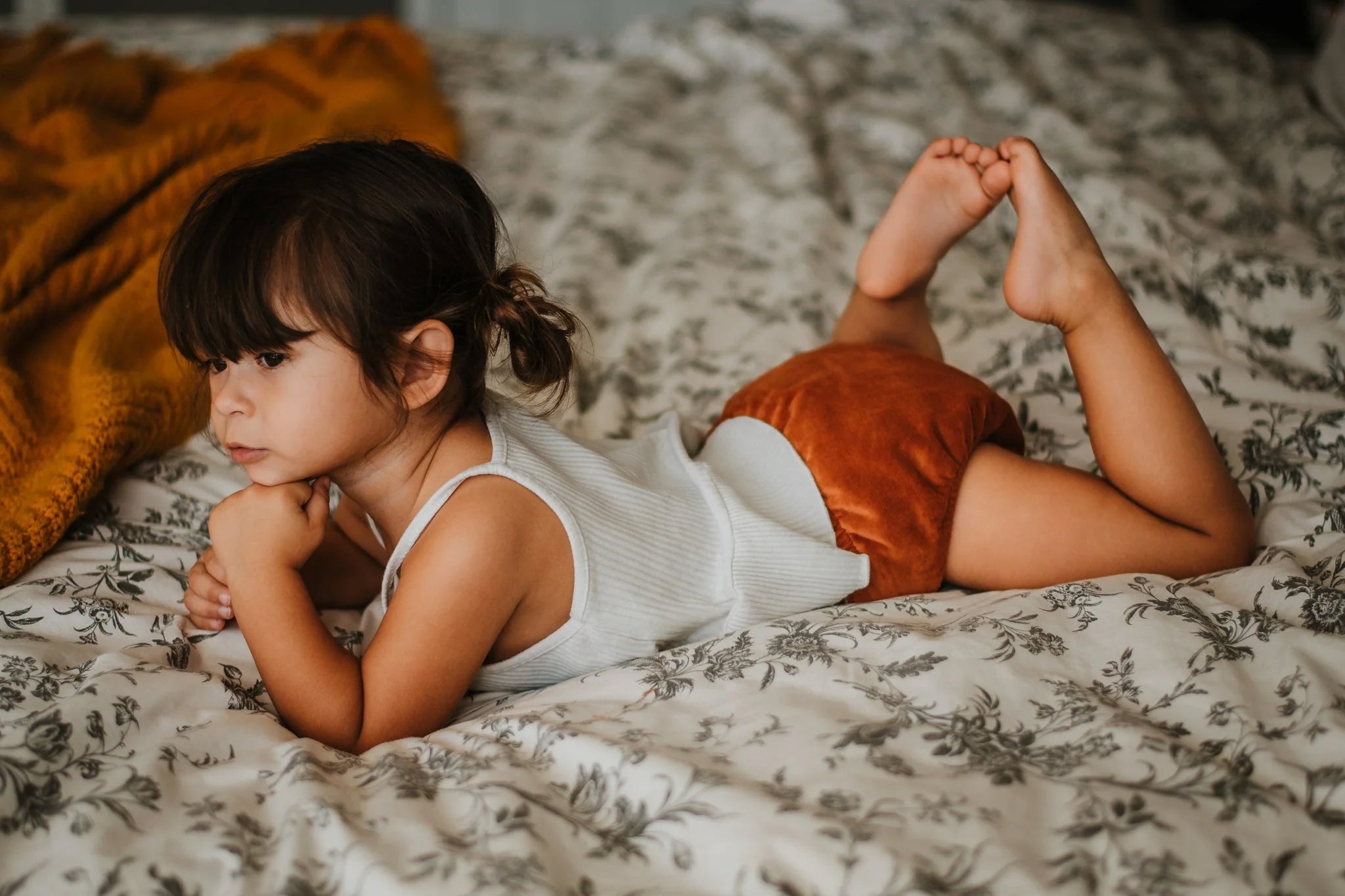 Young Kid Lounging in Orange Cloth Diaper