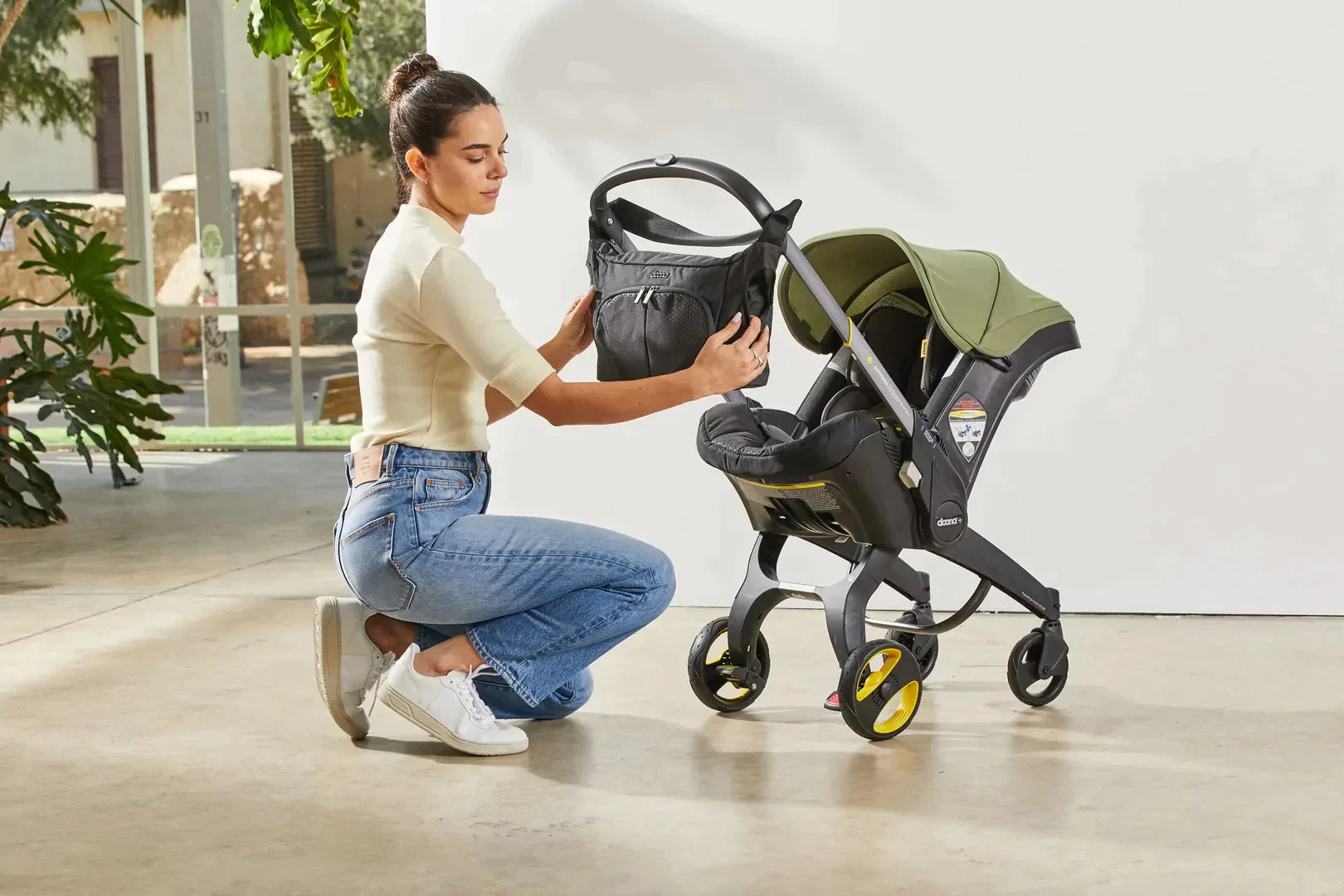 Woman Putting Bag on Doona Infant Car Seat & Stroller Travel System