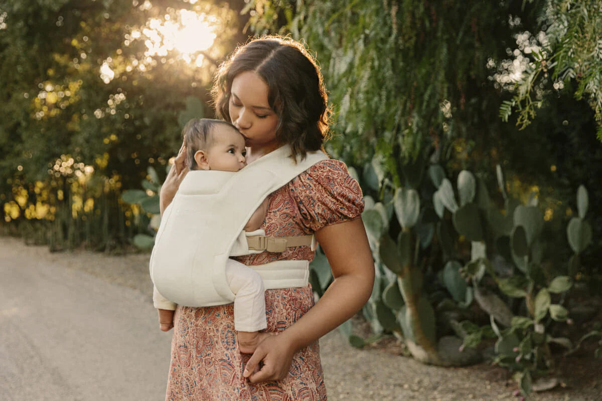 Woman Kissing Baby in Baby Carrier