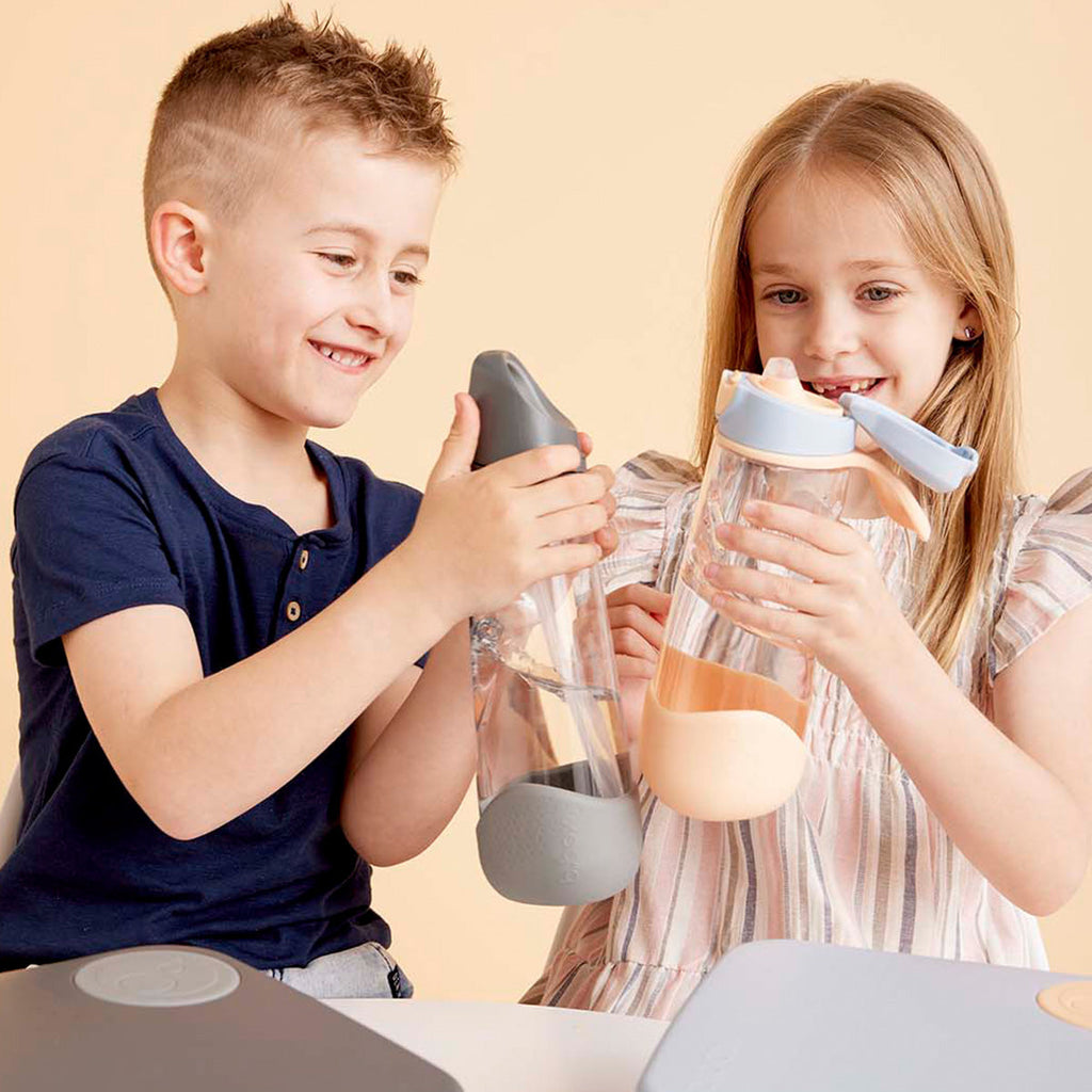 two children holding b.box sports spout water bottle smiling