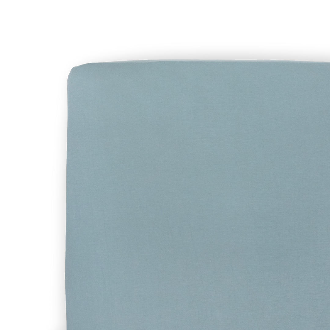 Folded neatly, the Little Unicorn Stretch Knit Crib Sheet in Harbor offers a soft and modern option for cozy crib sheets.