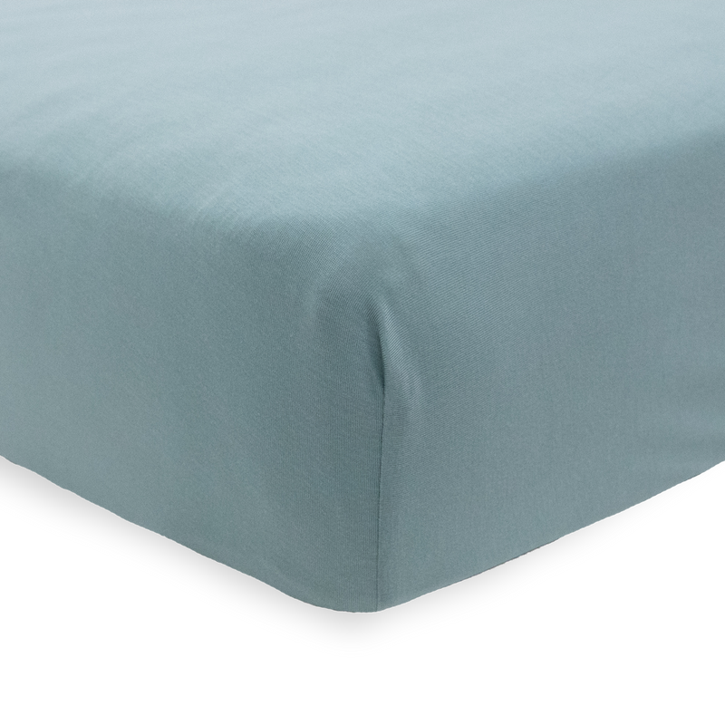 The Little Unicorn Stretch Knit Crib Sheet - Harbor fits snugly on the mattress, a stylish and durable fitted crib sheet.