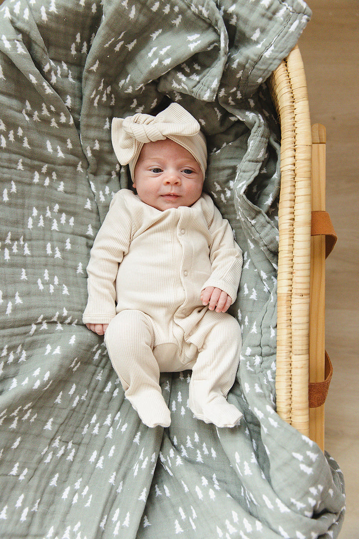 Laid flat to show the ribbed fabric, the Vanilla Organic Cotton Ribbed Snap from Mebie Baby.