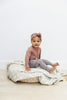 Little girl wearing the dusty rose organic bodysuit by Mebie Baby