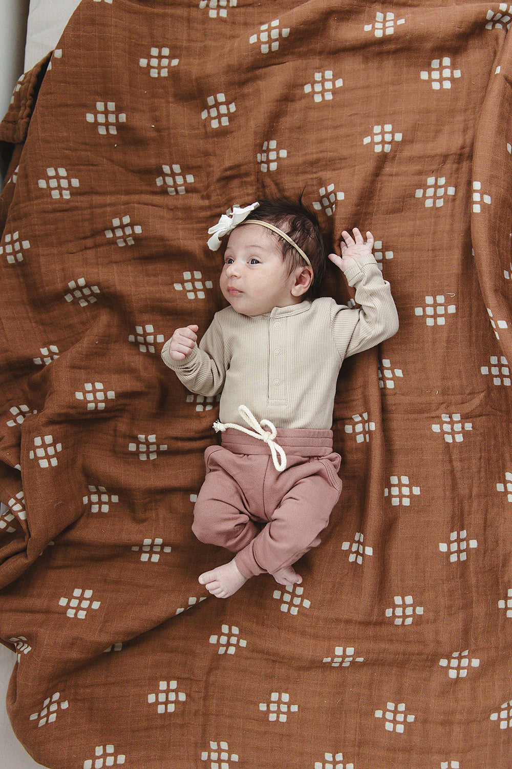 Laid flat to show the ribbed fabric, the Oatmeal Organic Snap Long Sleeve Ribbed Bodysuit from Mebie Baby.