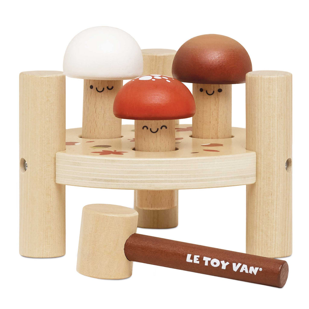 Three smiling wooden mushrooms sit in a round base beside a hammer stamped with the Le Toy Van name
