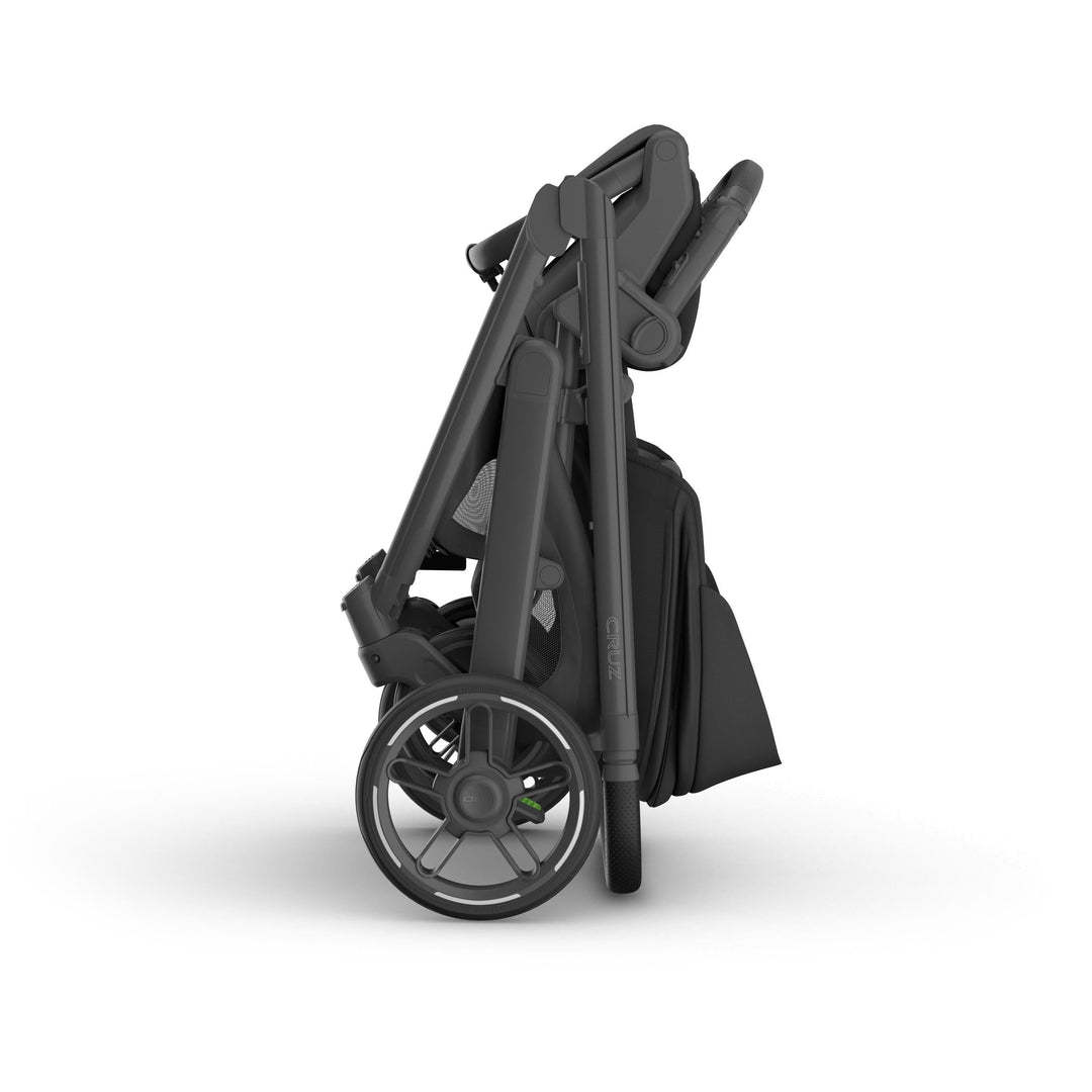 Compact folded Uppababy v3 stroller cruz in Jake, showing one handed fold and space saving design