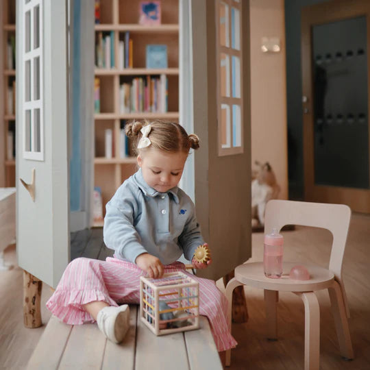 Child using Mushie Soft Spout Sippy Cup at library - toddler practicing independent drinking from BPA-free cup