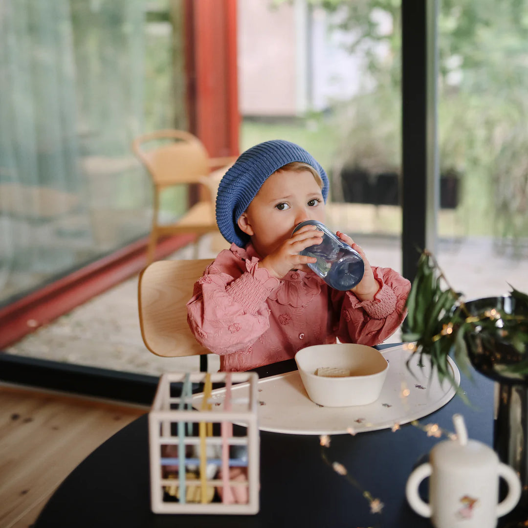 Mushie Soft Spout Sippy Cup Tradewinds at Christmas shoot - toddler with BPA-free silicone spout cup