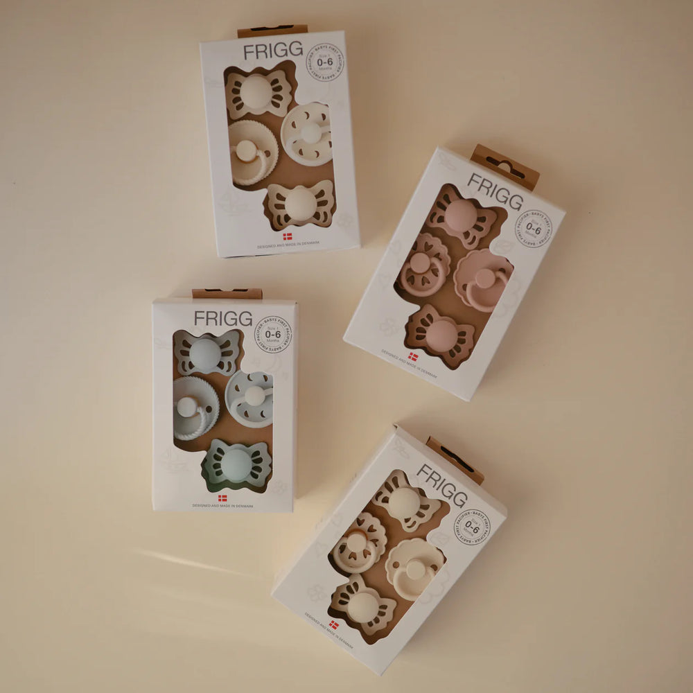FRIGG Moonlight Sailing Cream pacifier set contents - four mixed-style newborn pacifiers shown individually