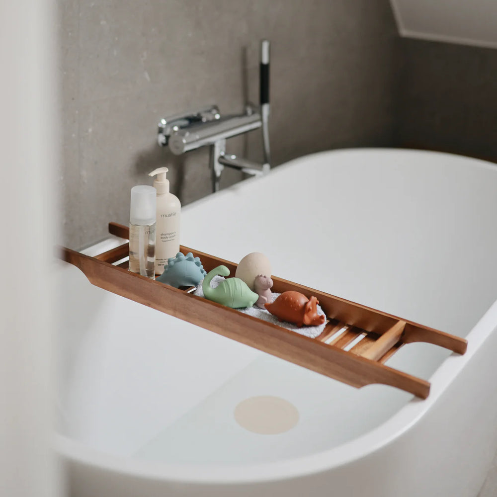 Child with Mushie Dino Bath Essentials Kit - toddler playing with dinosaur silicone bath toys at bath time