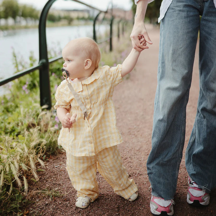 Shifting Sand Mushie Linen Pacifier Clip keeps your baby pacifier secure and stylish on the go.