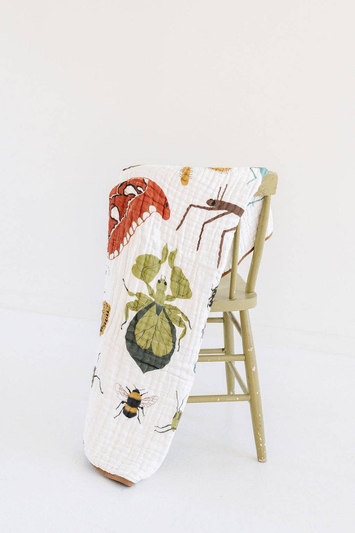 This Clementine Kids Cutie Crawlies Quilt doubles as a baby blanket with playful prints in breathable muslin.