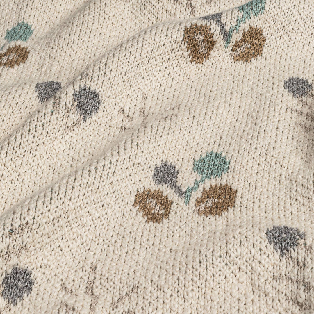 close up of crane organics baby blanket with green and brown poppy seed pattern 