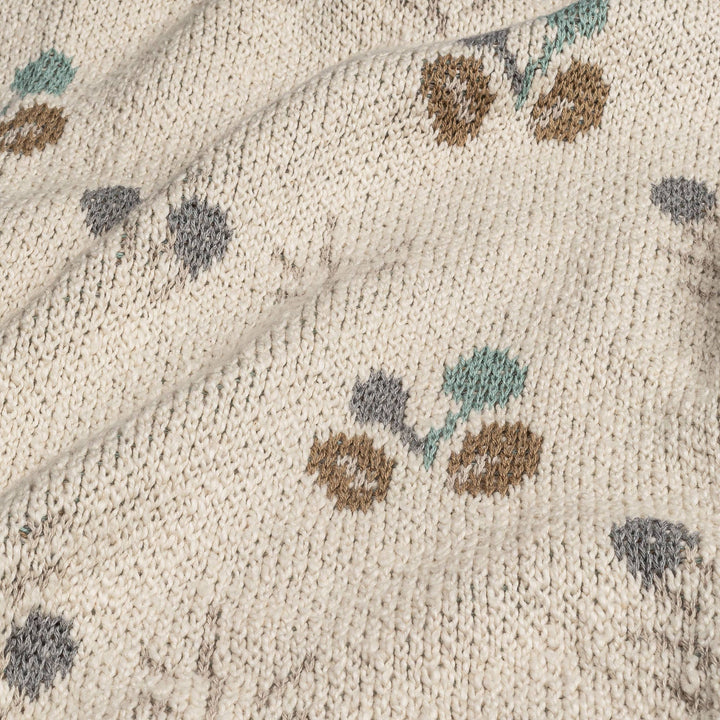 close up of crane organics baby blanket with green and brown poppy seed pattern 