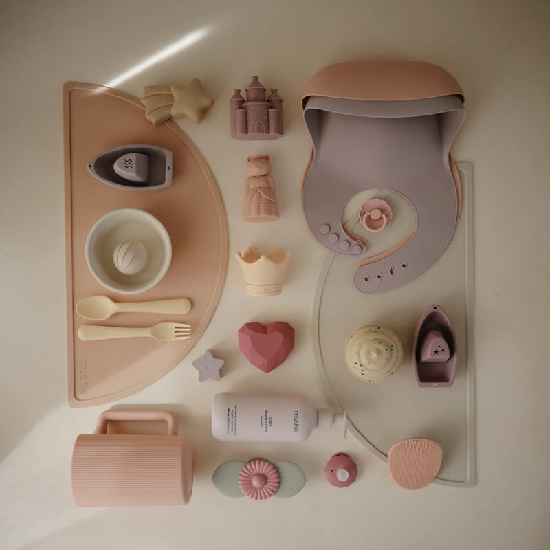 set of mushie products for baby girl in pink, purple, and yellow designed for baby girl bathtime 