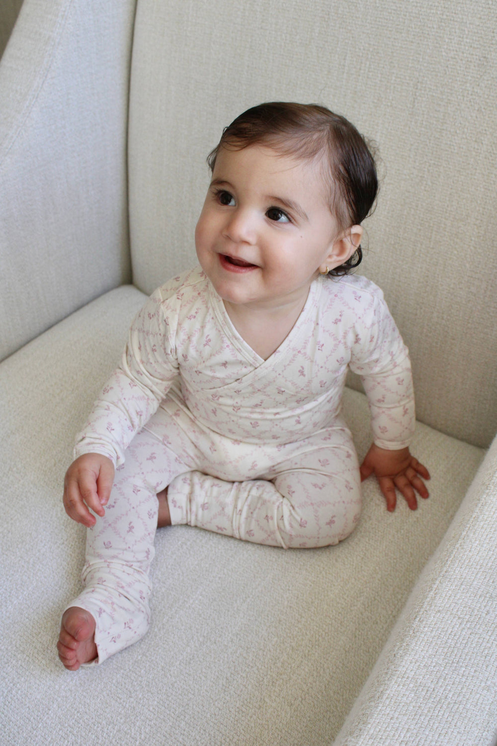 Baby wearing Little Threads mauve lattice bamboo footie in crib, cozy infant sleepwear for sensitive skin and soft bamboo baby pajamas