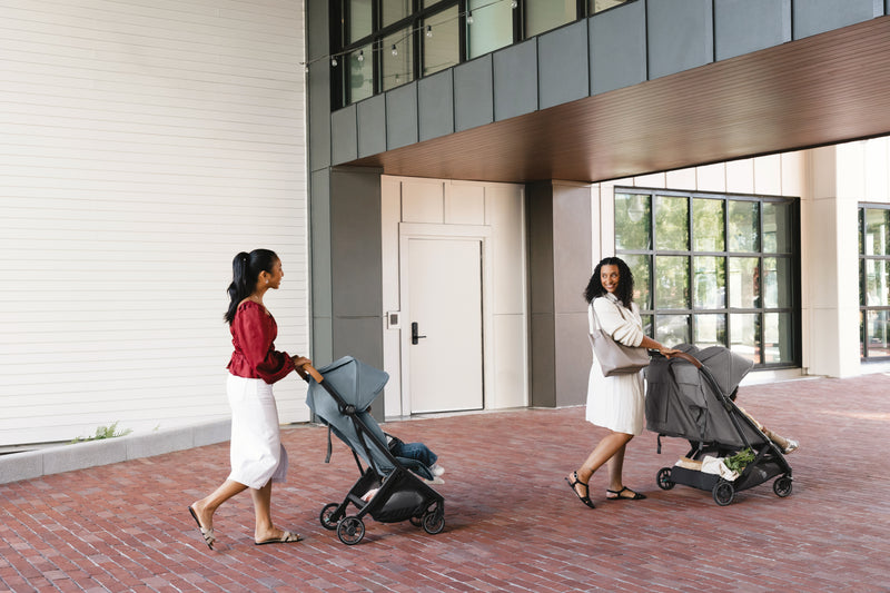 Parents enjoying a stroll with UPPAbaby Minu V3 Dillan toddler stroller, outdoor meetup. Stylish and family-friendly.