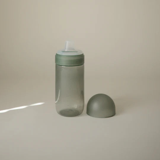 Mushie Soft Spout Sippy Cup styled flat lay - bottle-to-cup transition training cup with silicone spout detail