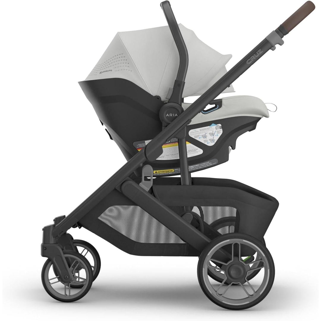 Uppababy Aria V2 Infant Car Seat in Savannah shown side-mounted on Cruz stroller, highlighting the perfect rear facing car seat for newborns.