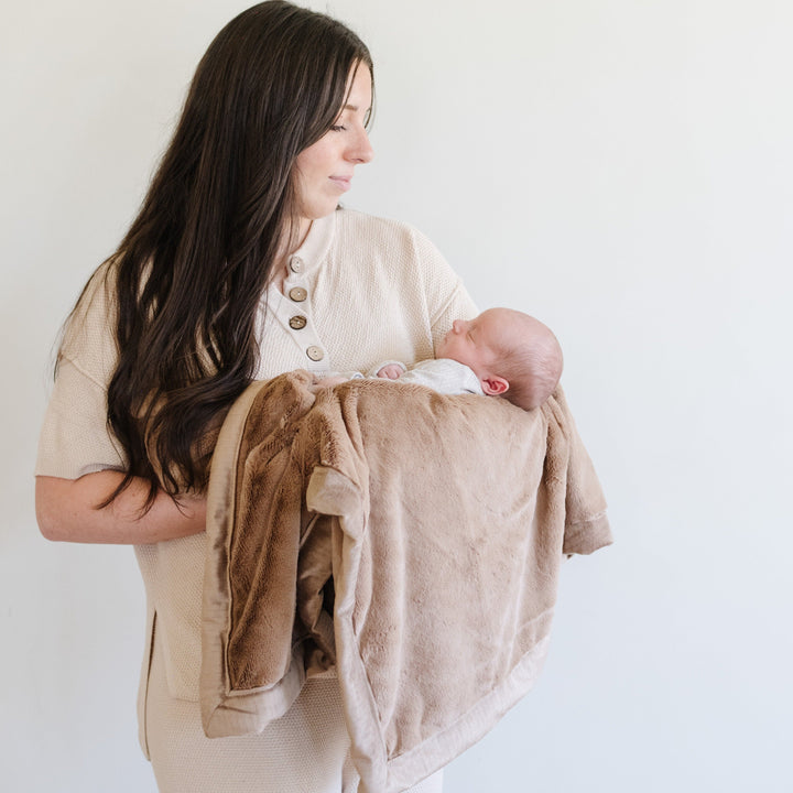 Snuggle your newborn with the Hazlenut Saranoni Lush Receiving Blanket, a luxurious receiving blanket.