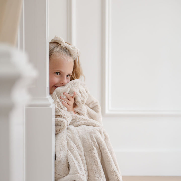 Wrap your newborn in the Buttermilk Saranoni Lush Receiving Blanket, a soft receiving blanket for gentle snuggles.