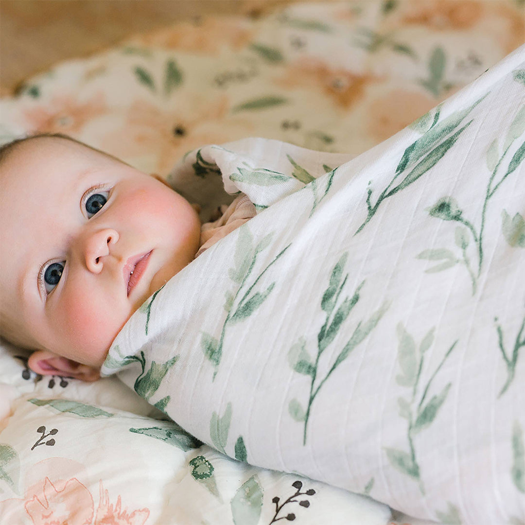 baby wrapped in parker green vine crane baby swaddle 