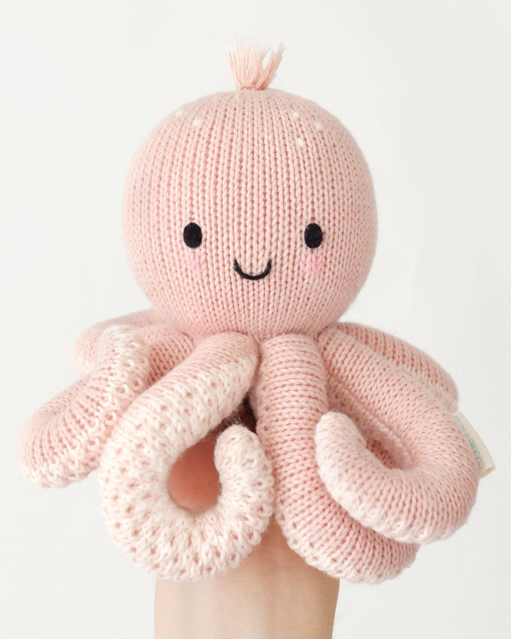 Baby Octopus in Soft Coral Pink by Cuddle + Kind, a 7-inch knit octopus stuffed animal that gives 5 meals
